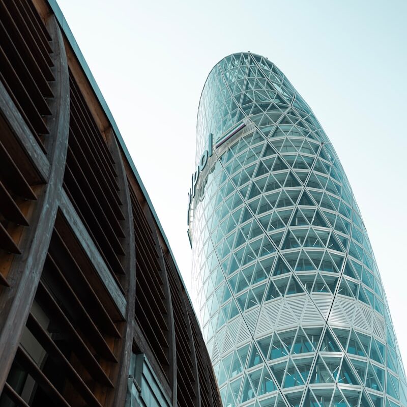 A tall glass building next to another tall building